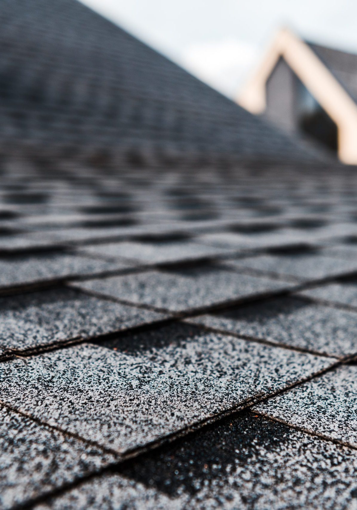 selective focus of grey shingles on rooftop of building